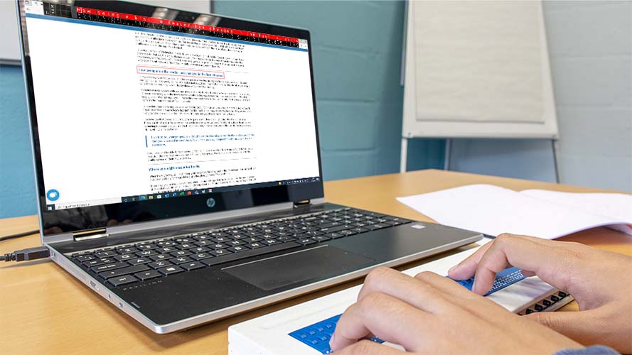 Obrázek braillského řádku připojeného k notebooku s programem SuperNova